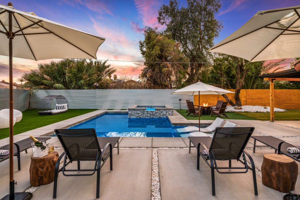 Pool lounge chairs with umbrellas at sunset